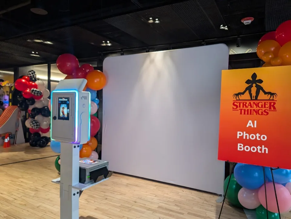 AI Photo Booth setup at Netflix event with Stranger Things signage and balloon decor