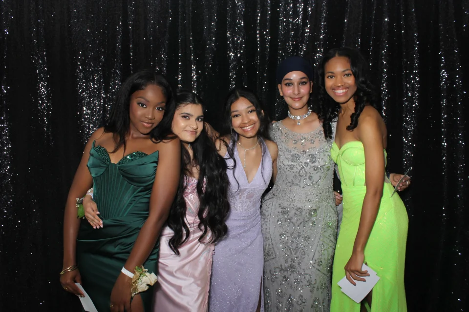 Prom photo booth rental NYC — guests in formal gowns at high school prom with sequin backdrop
