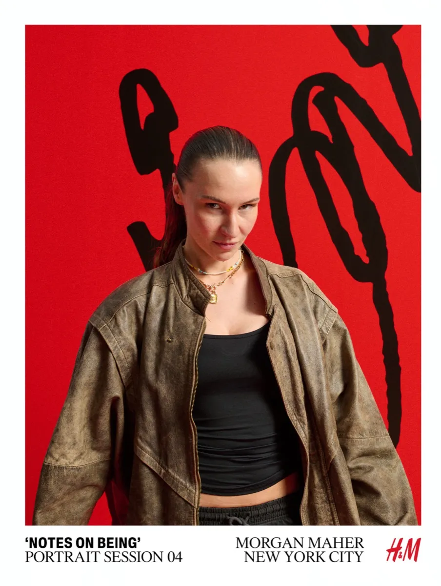 H&M Notes on Being portrait session by Morgan Maher — woman in vintage jacket posing against red backdrop with black brushstroke art in New York City