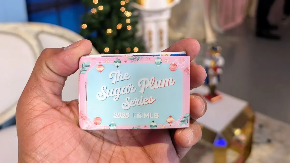 Custom branded MLB Sugar Plum Series flipbook held in hand at holiday party with Christmas tree and ornament decorations in background