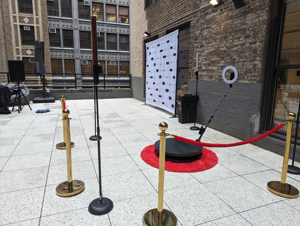 360 photo booth setup with red carpet and stanchions on NYC rooftop terrace for summer corporate event