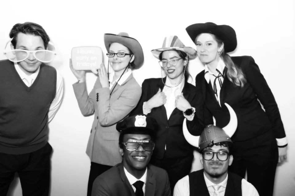 Corporate black and white photo booth NYC with branded print overlay and props