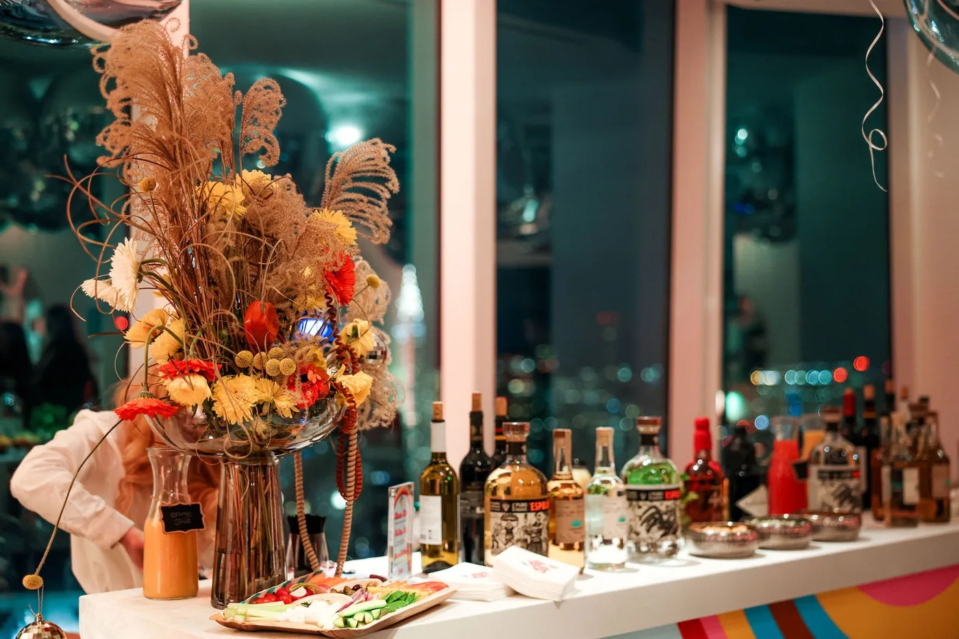 Event bar with florals against a New York City skyline at a corporate holiday party
