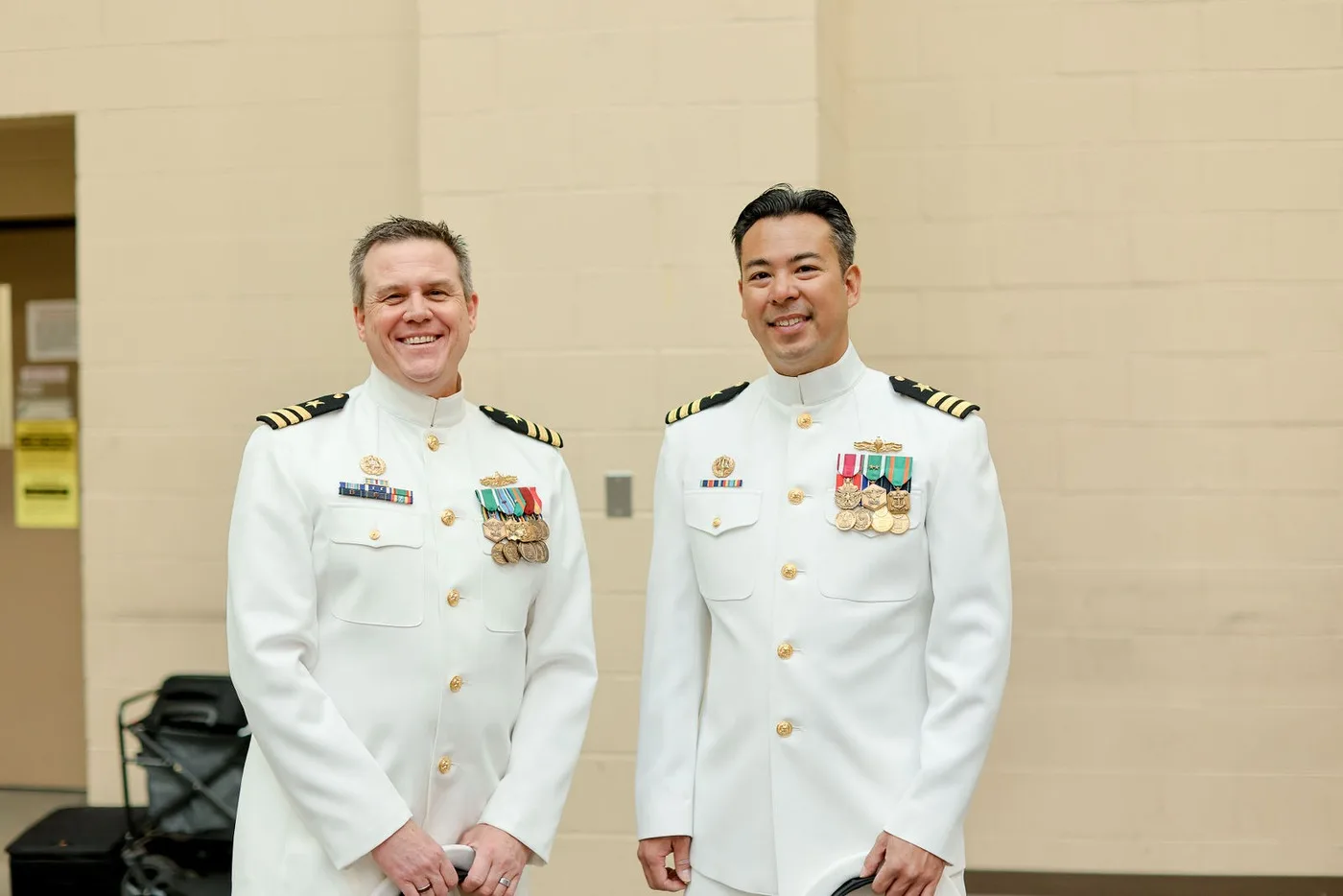 Two Navy officers in dress whites photographed at a change of command ceremony