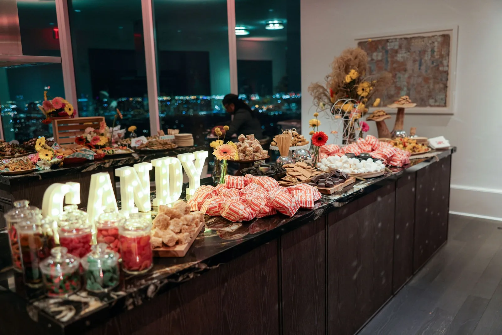 Corporate holiday party dessert display with Manhattan skyline windows