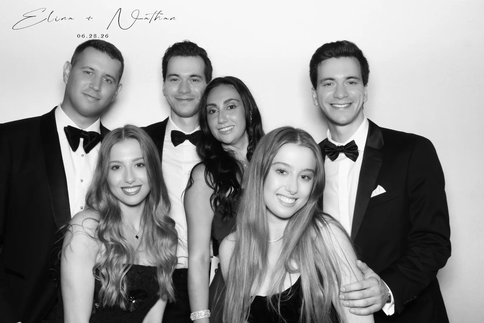 Glam photo booth rental NYC — black and white group portrait of six wedding guests in tuxedos and gowns