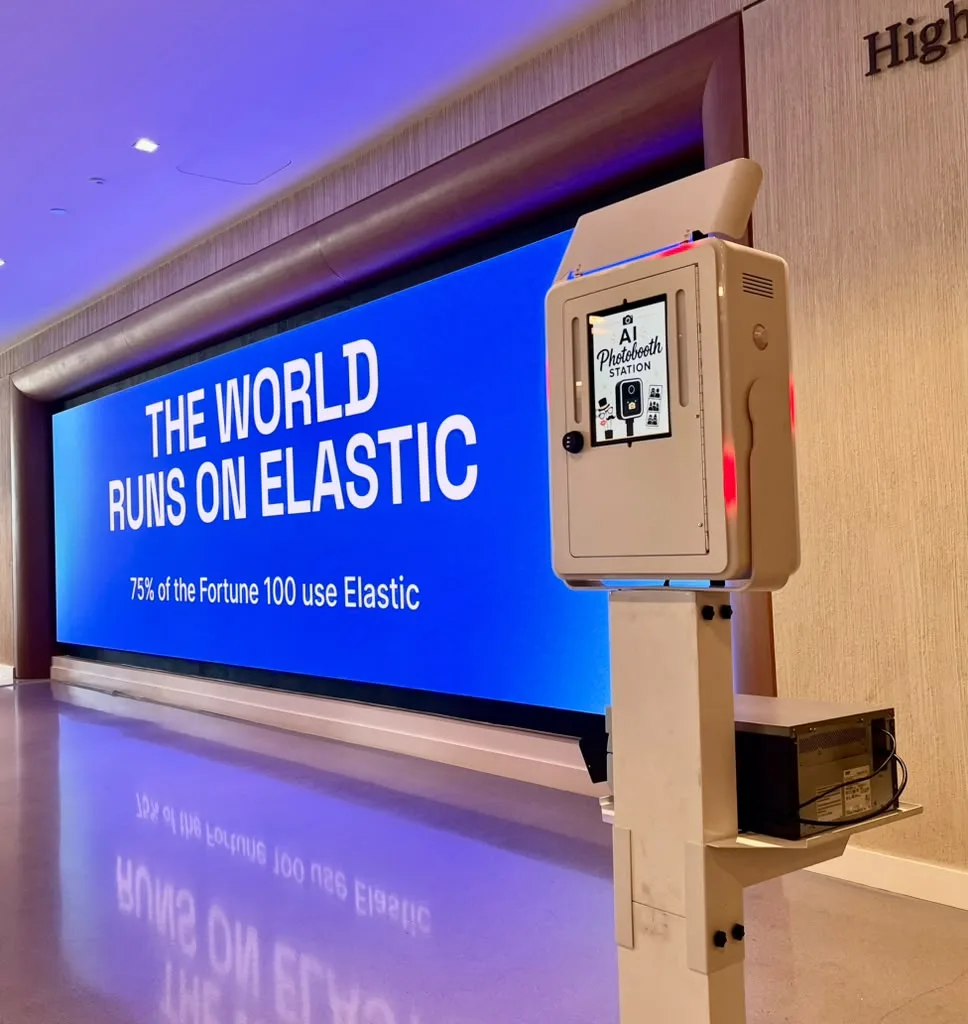 AI photo booth station beside an Elastic LED wall at a corporate event