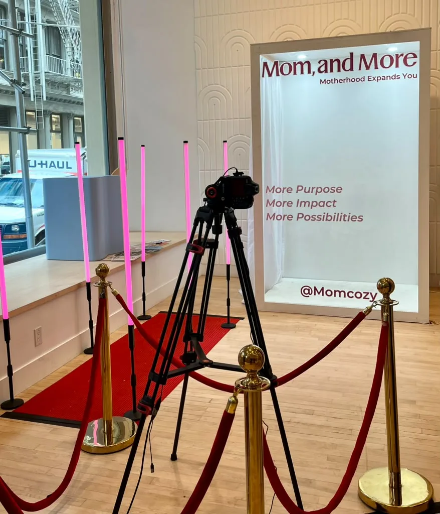 Momcozy magazine photo booth brand activation with red carpet and stanchions