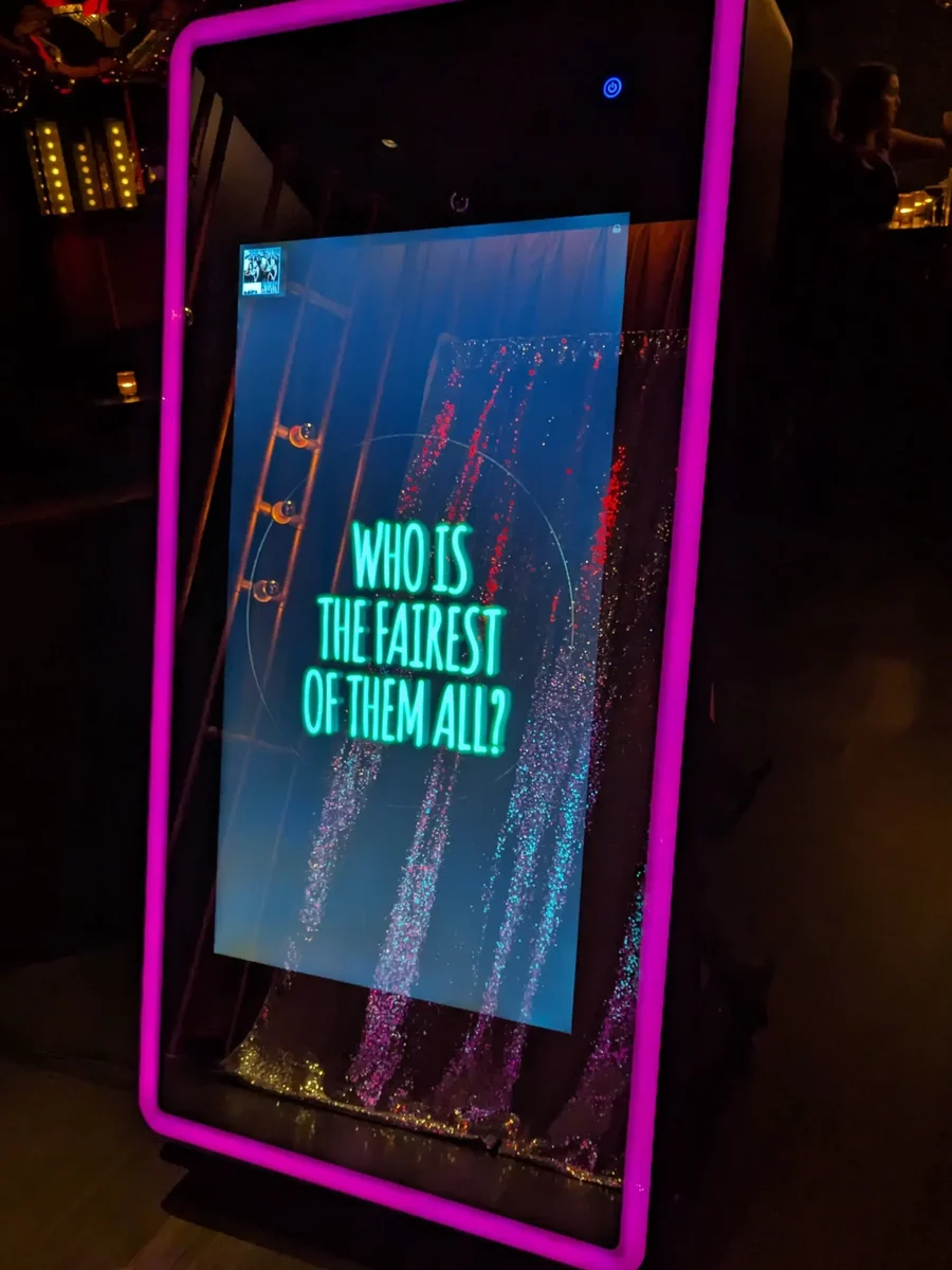Mirror photo booth with a glowing pink frame and animated touchscreen at a New York event
