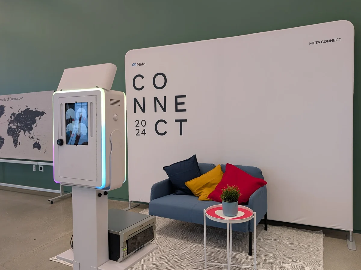 Open air photo booth with its printer beside the Meta Connect 2024 backdrop and lounge at a New York corporate activation